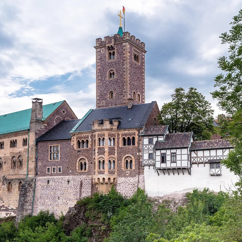 Die Wartburg, ein historisches Gebäude bestehend aus mehreren, in unterschiedlichen Stilen und mit verschiedenen Steinen erbauten Einzelteilen.