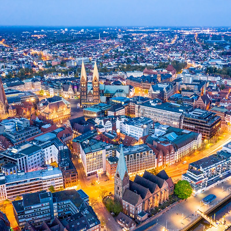 Eine Nachtaufnahme der Bremer Innenstadt zeigt die stimmungsvolle Beleuchtung von Marktplatz, Rathaus, Dom und den umliegenden Gebäuden.