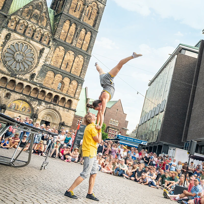 Ein akrobatischer Show-Act präsentiert einen Handstand vor Publikum.