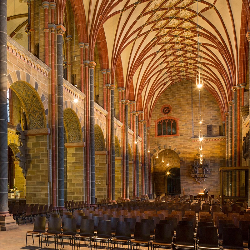 Eine Innenansicht des St. Petri Doms zeigt leere Stuhlreihen in stimmungsvoller Beleuchtung.