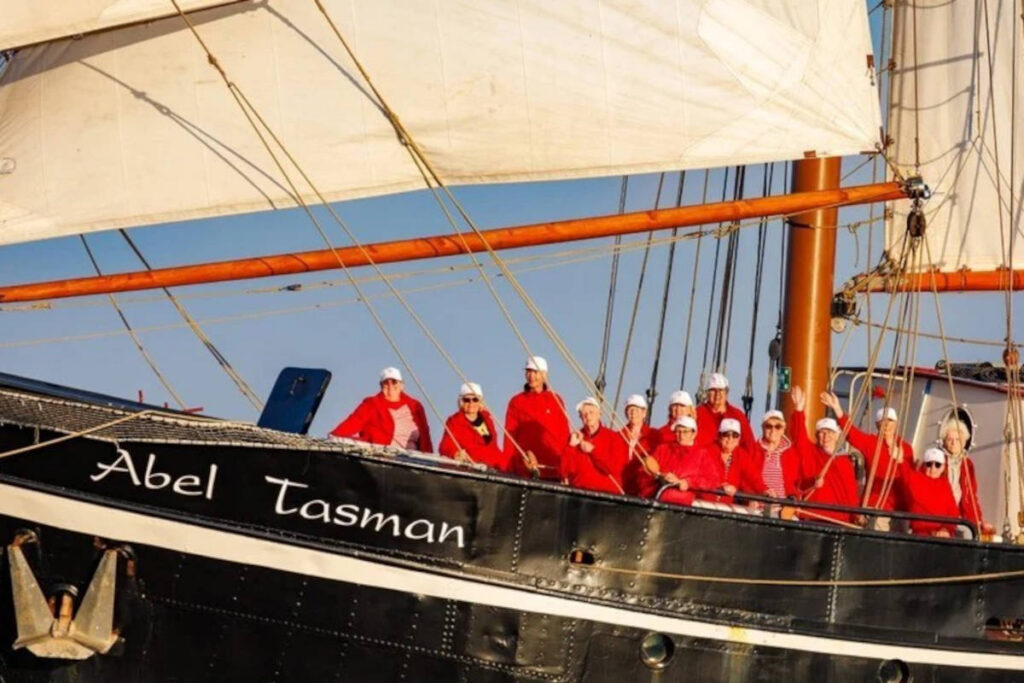 Ein Chor steht auf einem Segelschiff.